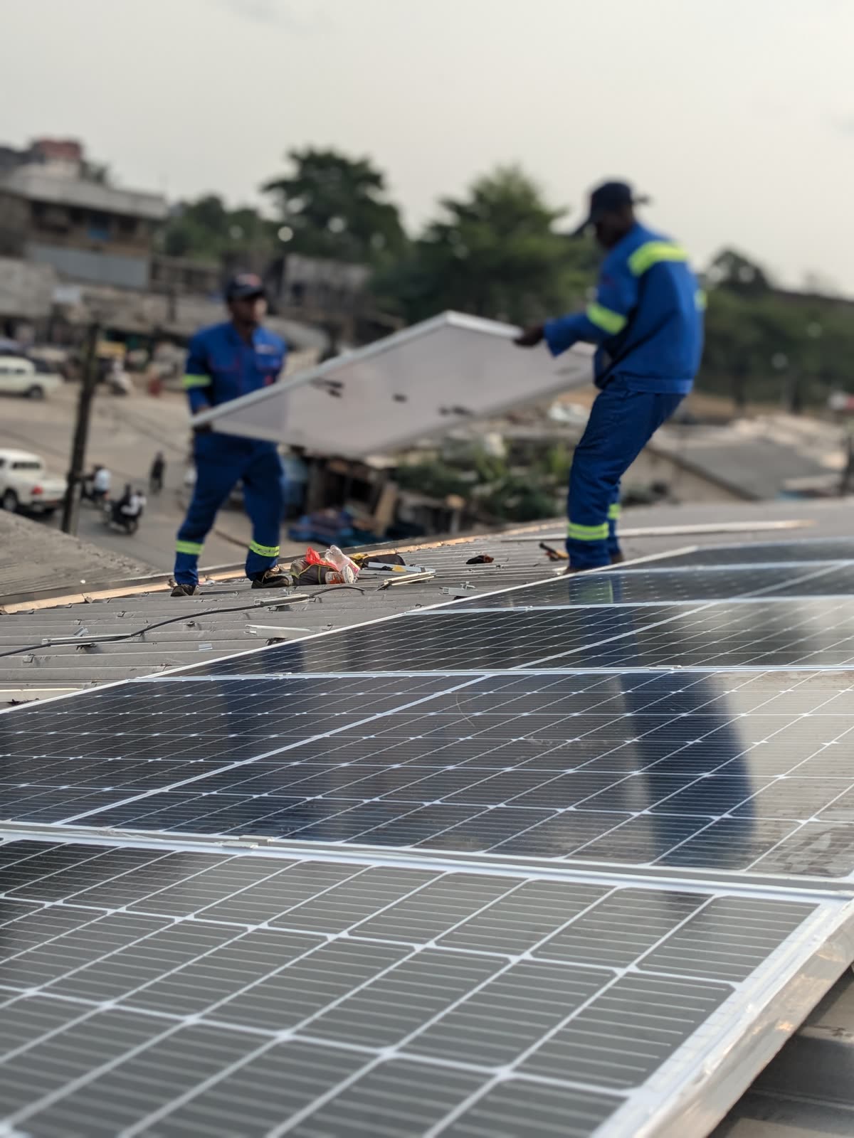 SmartSana crew laying panels on a Douala rooftop