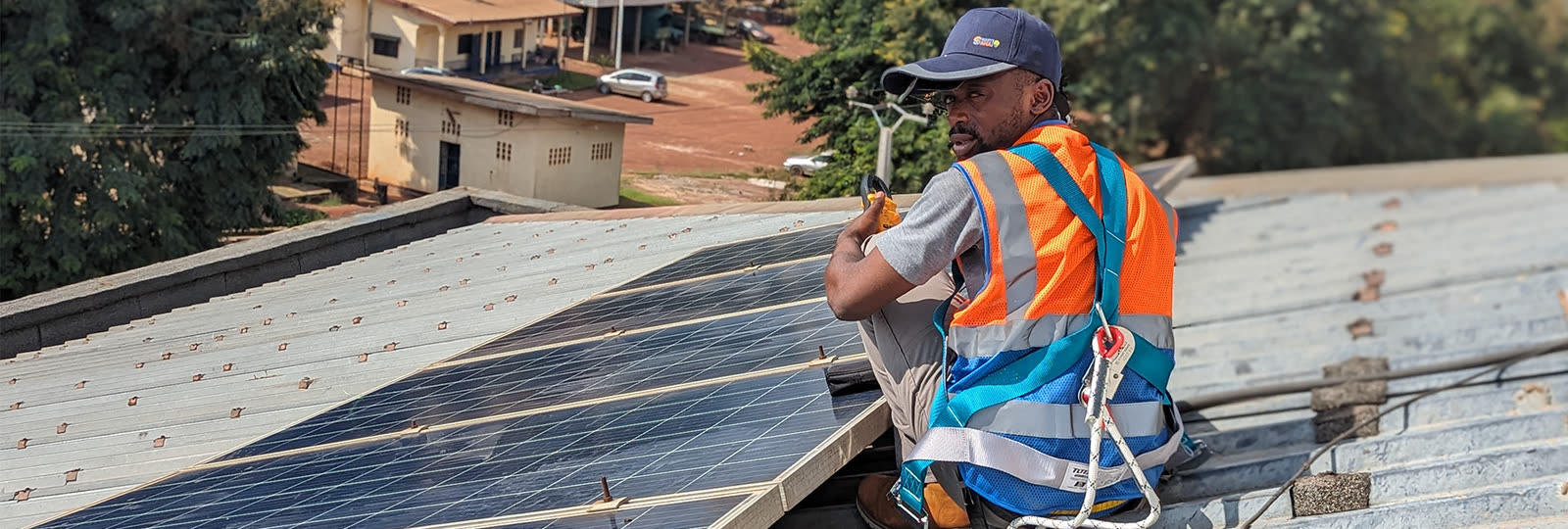 SmartSana technician in a harness working on a solar roof