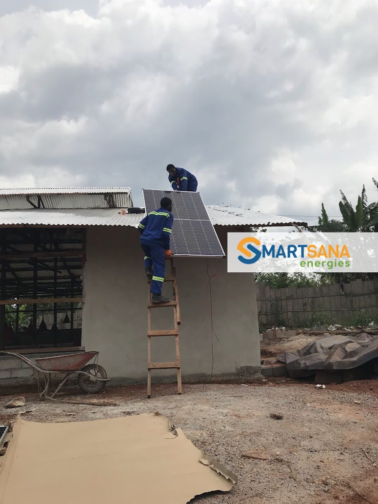 Technician mounting panels on the roof, Awaé farm