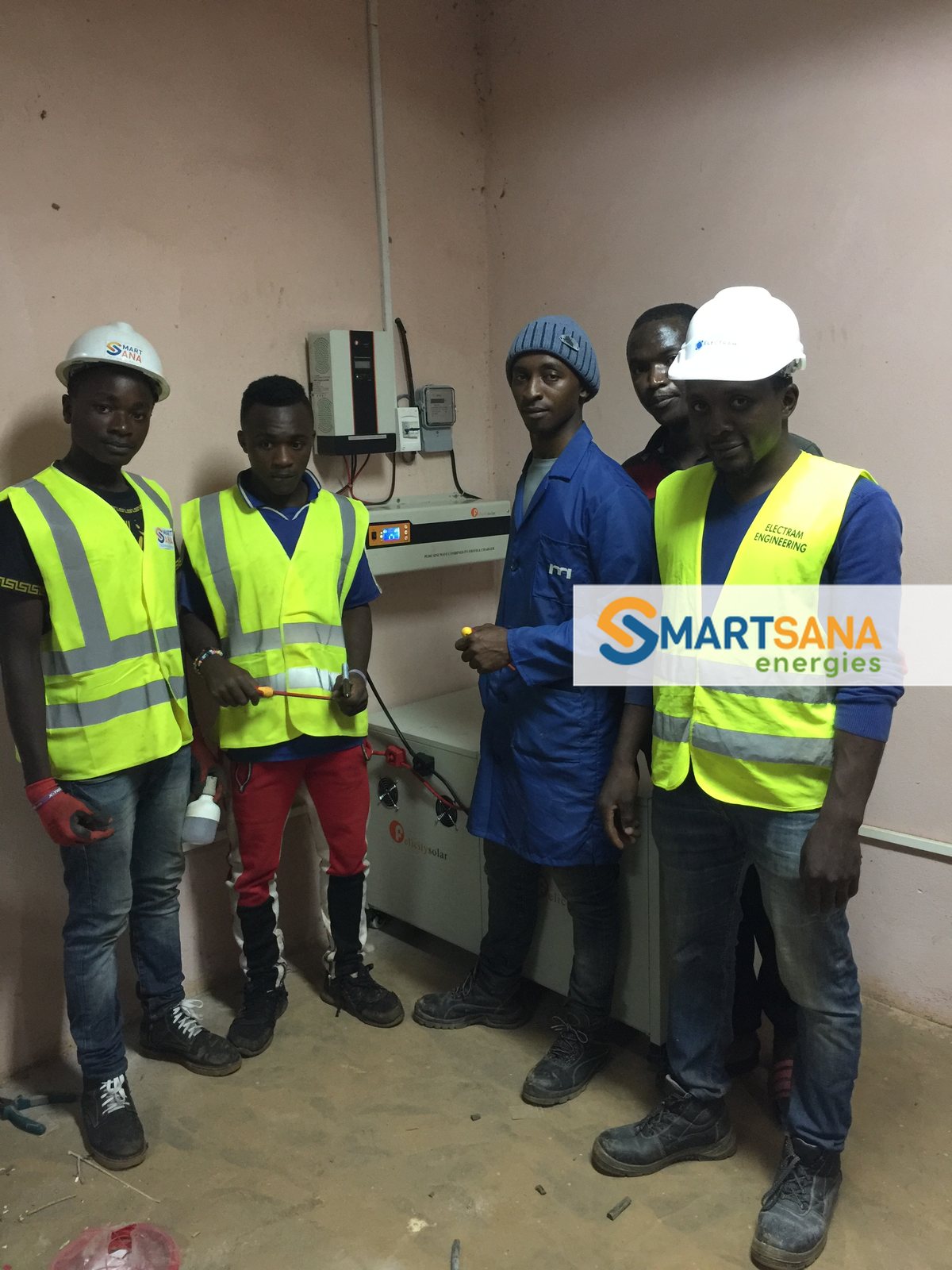The installation crew beside the inverter and batteries